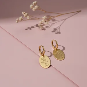 Elegant gold earrings on pink