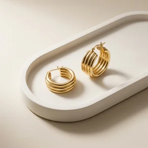 Minimalist gold hoops on concrete tray
