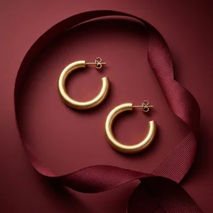Gold hoop earrings on burgundy ribbon