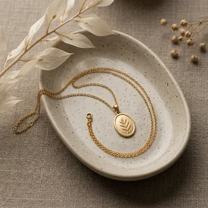 Gold leaf necklace on ceramic tray