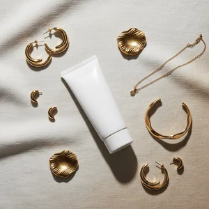 Skincare & gold accessories flat lay