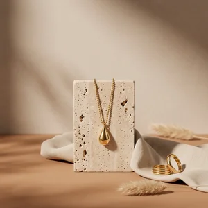 Gold necklace on travertine stone