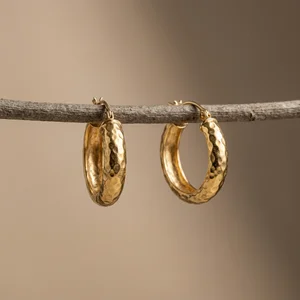 Gold hoop earrings on natural branch