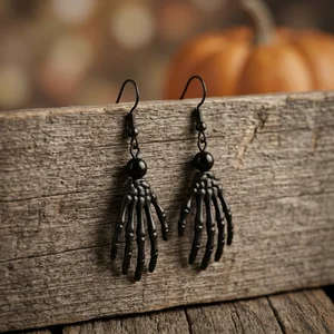 Skeleton hand earrings on rustic wood