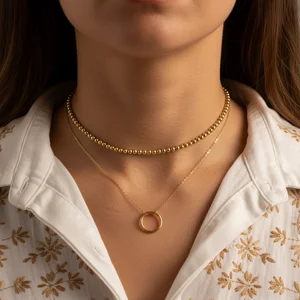 Layered gold necklace on model