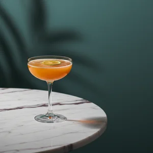 Golden cocktail with lime garnish