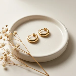Gold hoop earrings on ceramic dish