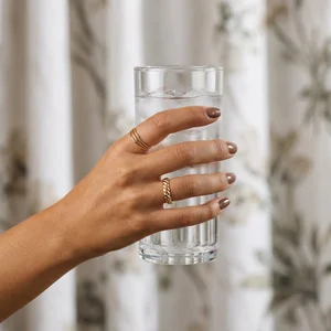 Hand holding iced water glass