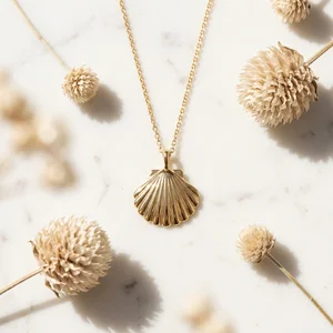 Gold seashell necklace on marble