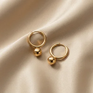 Delicate golden earrings on silk