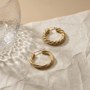 Gold twisted hoops on textured paper