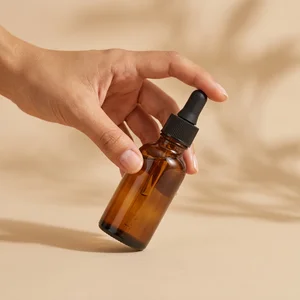 Hand holding amber dropper bottle