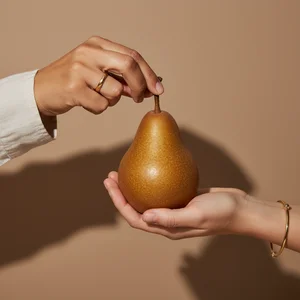 Hands delicately holding a pear