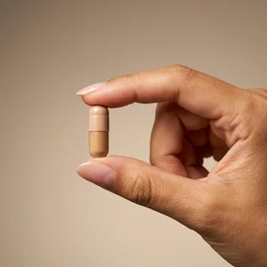 Hand holding supplement capsule