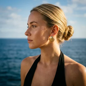 Gold shell earring by the ocean