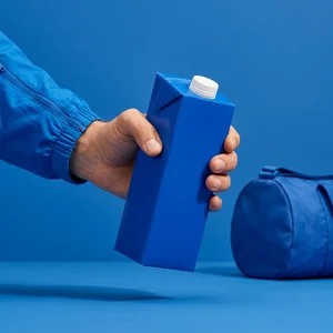 Blue carton in hand with gym bag