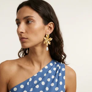 Model wearing gold and white earrings
