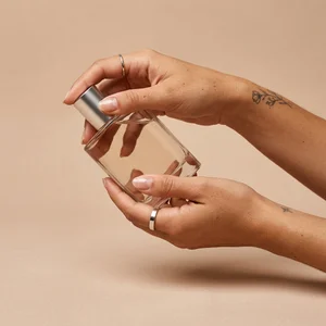 Delicate hand holding beauty bottle