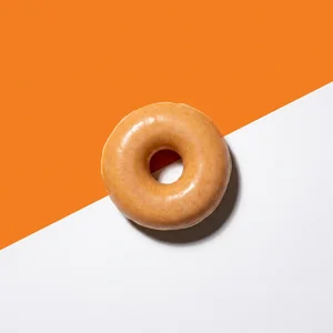 Minimalist glazed donut on orange