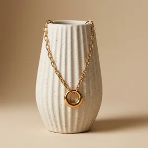 Gold necklace on textured vase
