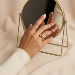 Gold ring and mirror on fabric