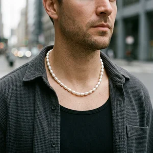 Men's pearl necklace on city street