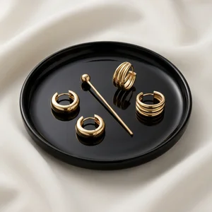 Gold jewelry on black plate