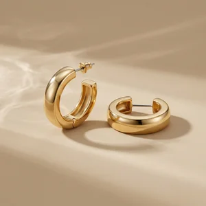Gold hoop earrings on beige