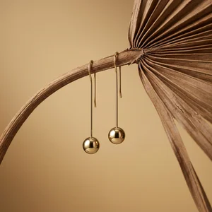 Minimalist gold earrings on palm