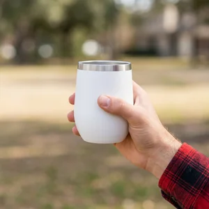 Hand holding tumbler outdoors