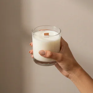 Hand holding wooden wick candle