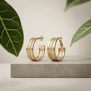 Gold leaf earrings on concrete
