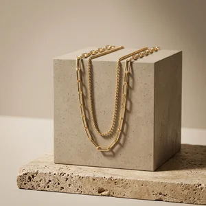 Modern gold necklaces on concrete