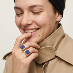 Smiling woman in trench coat with rings