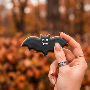 Halloween bat cookie in autumn leaves