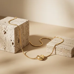 Gold necklace on travertine stone