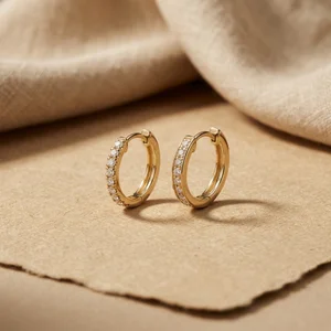 Gold diamond hoop earrings on paper