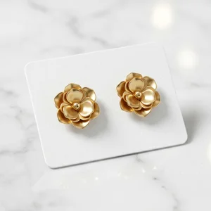 Gold flower earrings on marble