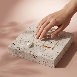Layered gold necklace on concrete