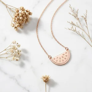 Gold necklace on marble with flowers