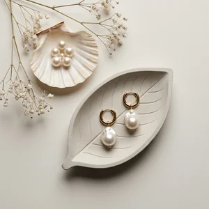 Elegant pearl earrings on leaf tray