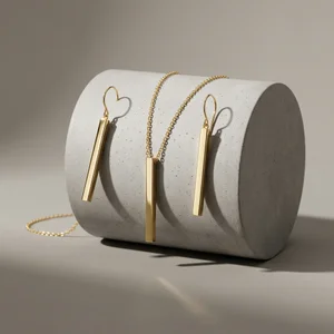 Minimalist gold jewelry on concrete