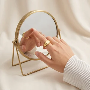 Gold ring and mirror on fabric