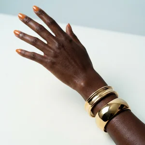 Gold cuffs and orange nails