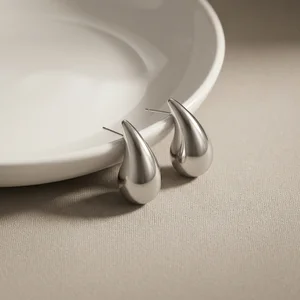 Minimalist silver earrings on fabric