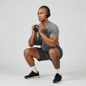 Male model squatting with dumbbell