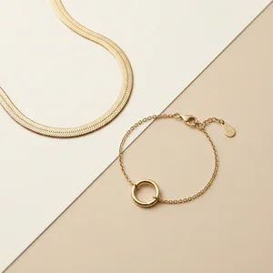 Minimalist gold jewelry on beige