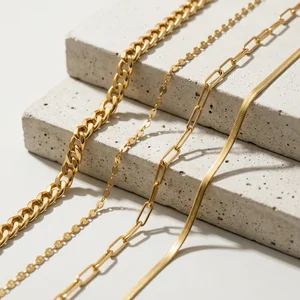 Layered gold chains on concrete