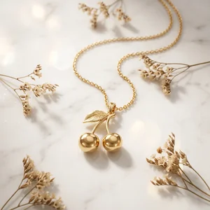 Gold cherry necklace on marble