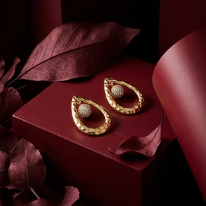 Elegant gold earrings on red wood